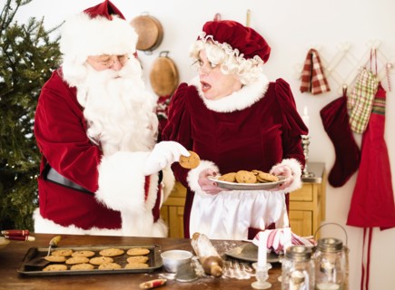 Santa stealing gingerbread cookie from Mrs. Claus.
