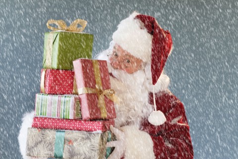 Portrait of Santa Claus carrying Christmas presents.