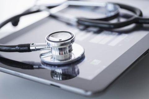 Stethoscope lying on digital tablet.