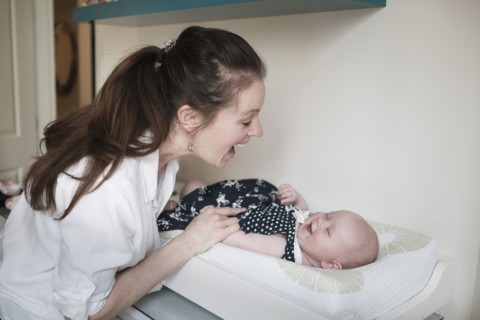 Mother playing with baby daughter (2-5 months).