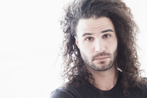 Portrait of young man with long curly hair.