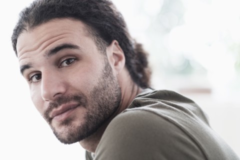 Portrait of young man with long curly hair.