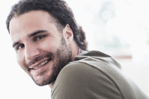 Portrait of young man with long curly hair.