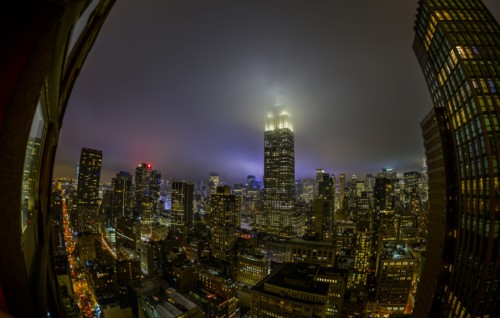 Empire State Building shrouded in night fog. USA, New York, New York City.