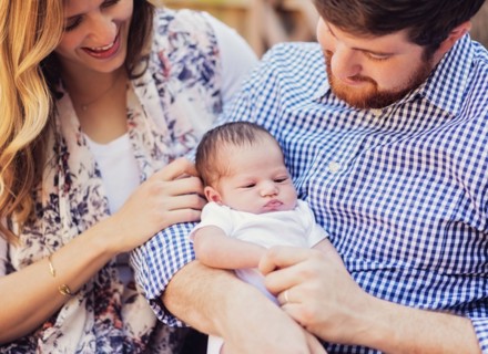Happy parents holding girl (2-5 months)