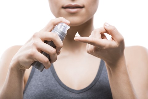 Young woman applying moisturizer