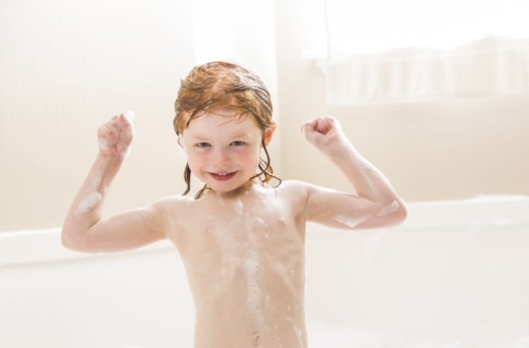 Smiling girl (4-5) having bubble bath