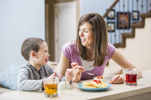 Mother and son (6-7) eating breakfast