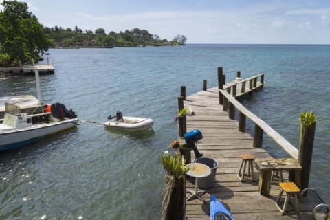 Wooden jetty with motor boat nearby on sea