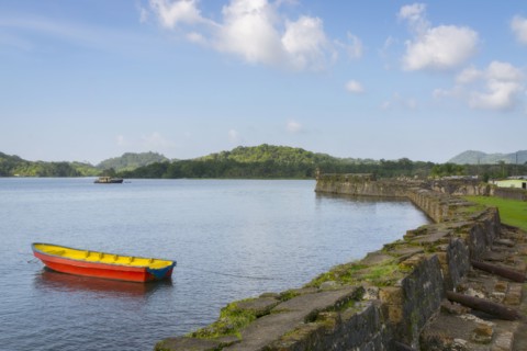 Boat on bay moored by stone wall