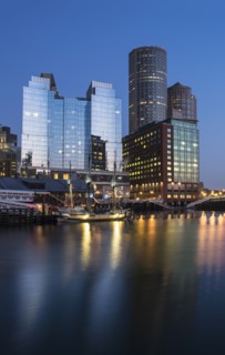 Skyscrapers reflecting on water surface at dawn