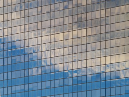 Sunlight and clouds reflecting in windows of office building