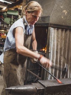 Female blacksmith working in workshop