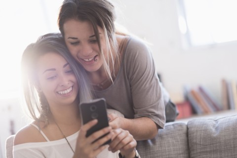 Young women using mobile phone at home.