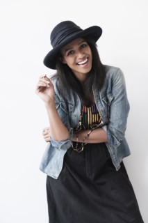 Studio portrait of mid adult woman in hat and denim jacket.