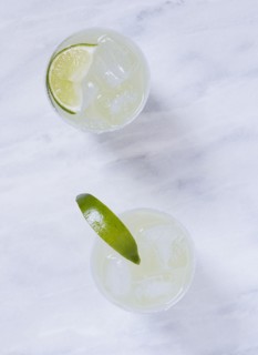 Overhead view of two margaritas on marble table