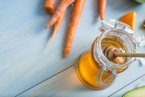 High angle view of jar of honey and carrots