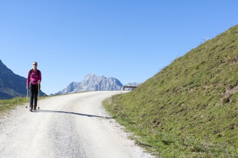 Austria, Salzburger Land, Weissbach, Mature woman hiking on sunny day in mountain landscape