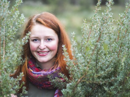 Portrait of smiling redhead in bushes