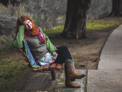 Young woman sitting on bench in park