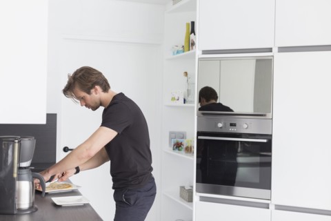 Mid-adult man preparing breakfast in modern kitchen