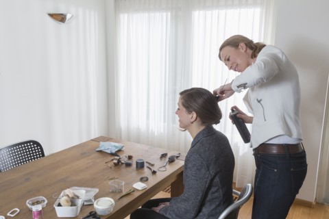 Woman styling other woman's hair