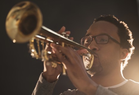 Mid adult man playing trumpet.