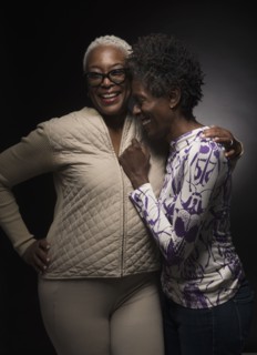 Two women laughing and standing in embrace.