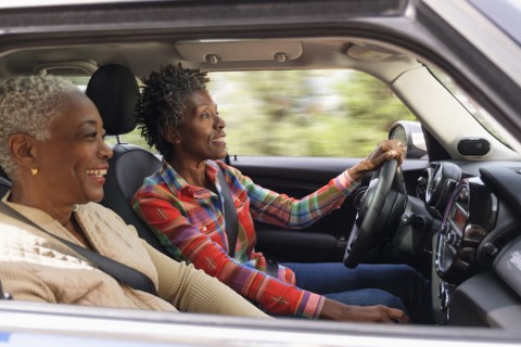 Two smiling women in car.