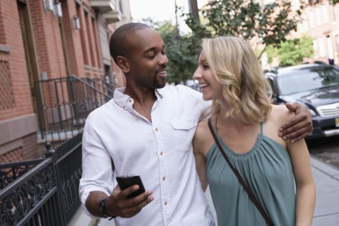 Smiling couple walking in residential district.