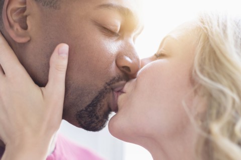 Multi ethnic couple kissing.