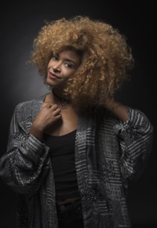 Portrait of smiling blond woman on black background.