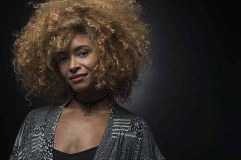 Portrait of cool blond woman on black background.