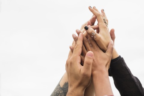 Friends holding their hands together.