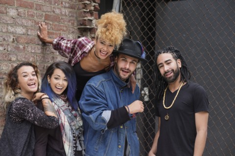 Portrait of happy friends against brick wall.
