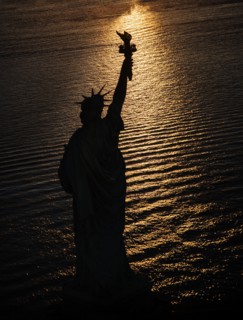 USA, New York State, New York City, Silhouette of Statue of Liberty at sunrise.