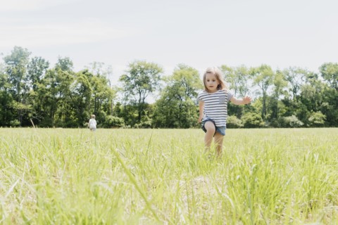 USA, Pennsylvania, Washington Crossing, Girl (2-3) and boy (4-5) walking on green field