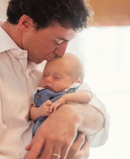 Father kissing baby son (0-1 months)