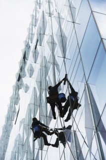 USA, New York, New York City, Windows washers cleaning glass facade of office building