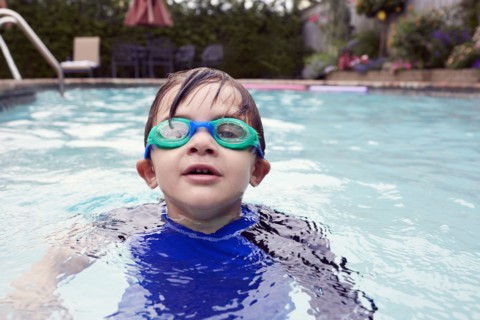 Boy (4-5) playing in pool