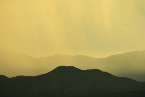 USA, Colorado, Denver, Rain against colorful sky above rocky mountains