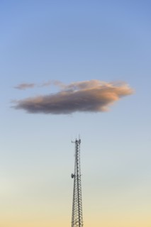 Cloud over communication tower at dusk