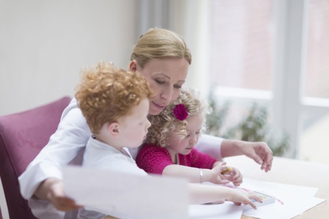 Mother looking at drawings with son (8-9) and daughter (4-5)