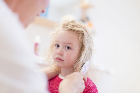 Mother brushing daughter's (4-5) hair