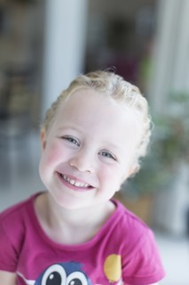 Portrait of blonde girl (4-5) looking at camera and smiling