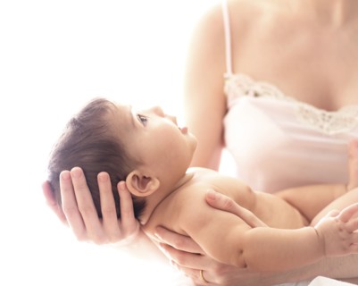 Baby girl (6-11 months) held by mid-adult woman.