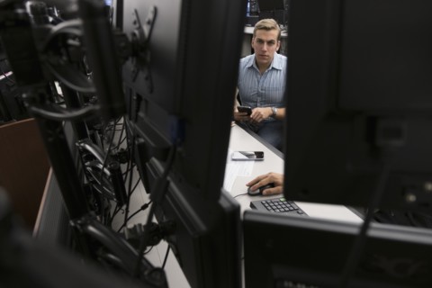 Young traders analyzing computer data.
