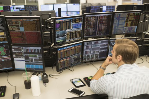 Young trader analyzing computer data.