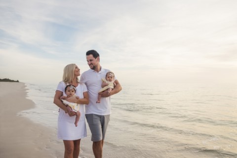 Couple with twins (2-5 months) walking along seashore