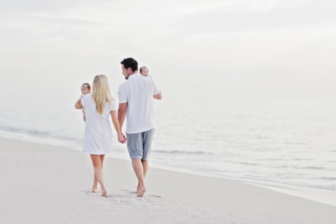 Parents walking with babies (2-5 months) along seashore